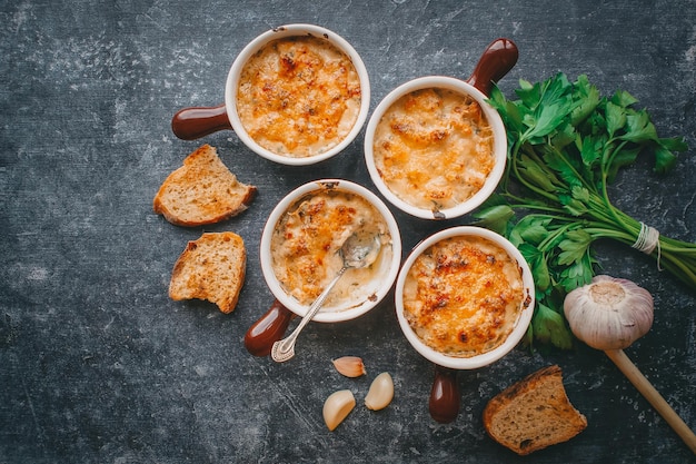 Julienne in porties, Champignons met room en kaas, Restaurantvoedsel op een donkere achtergrond