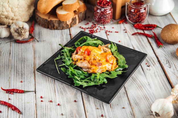 Julienne onder de kaas met rucola op de houten versierde tafel