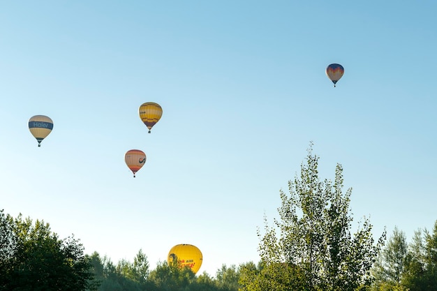 July 30 2022 Russia Pereslavl Zalessky Lake Pleshcheyevo Hot air balloons in clear blue sky over forest and lake