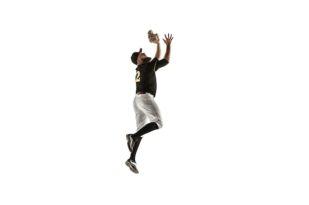 In jump. Baseball player, pitcher in black uniform practicing and training isolated on white wall. Young professional sportsman in action and motion. Healthy lifestyle, sport, movement concept.