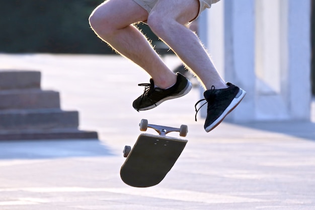 Прыгайте, чтобы подбросить парня на скейтборде. спорт и отдых для подростков