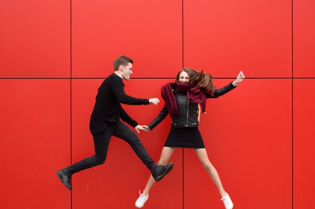 jump. A man and a woman on a red background.