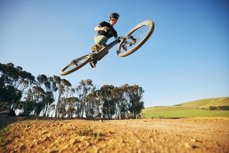 Photo jump mountain bike and man outdoor in nature for extreme sports training or workout sky air or wellness of male person with courage or bicycle stunt for off road cycling travel or adventure