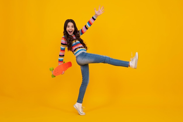 Jump and run amazed teenager teen school girl with skateboard on studio isolated background spring schoolgirl trend urban teenager style excited teen girl