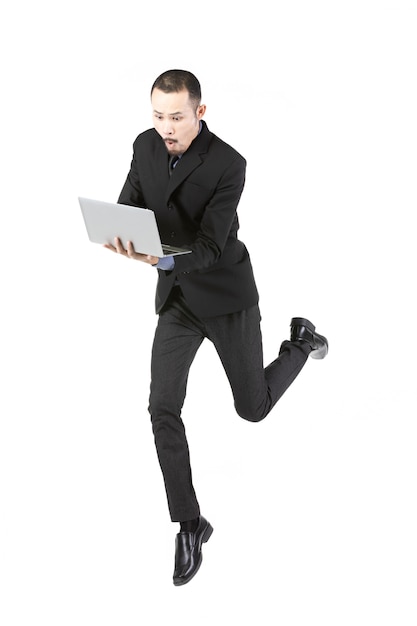 흰색에 고립 된 노트북 컴퓨터와 사업가 점프