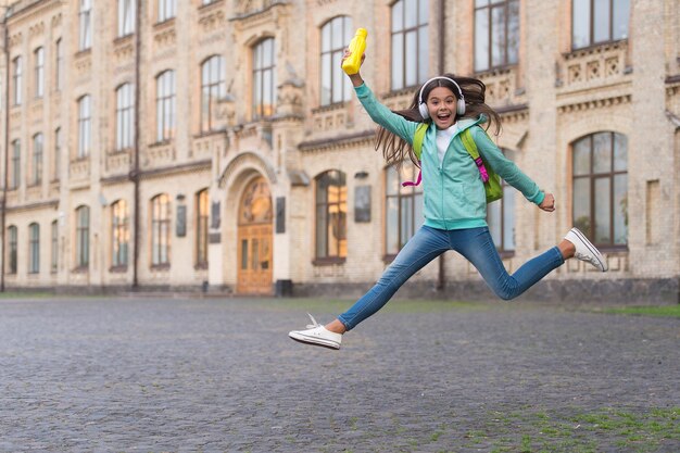 Jumping happy child feel freedom and joy with water bottle outdoor, childhood happiness.