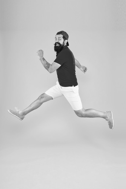 Jumping up in air having fun time rejoicing Like a rock star hipster celebrating success Keep moving Run hard hurry up man is fast rush hour Last chance bearded man run away