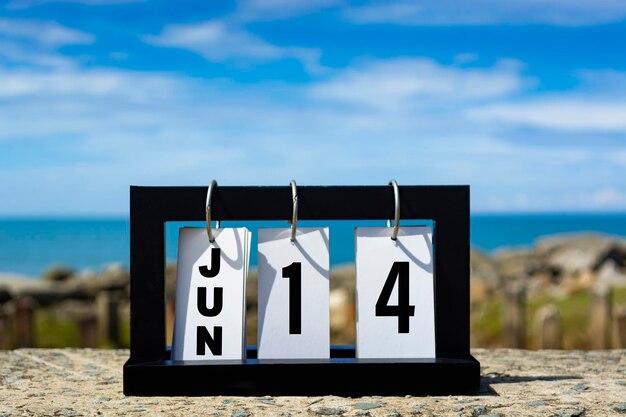 Photo jun 14 calendar date text on wooden frame with blurred background of ocean calendar date concept