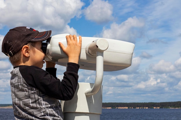On June 19 2022 in Cheboksary a boy looks through a binocular telescope for tourists