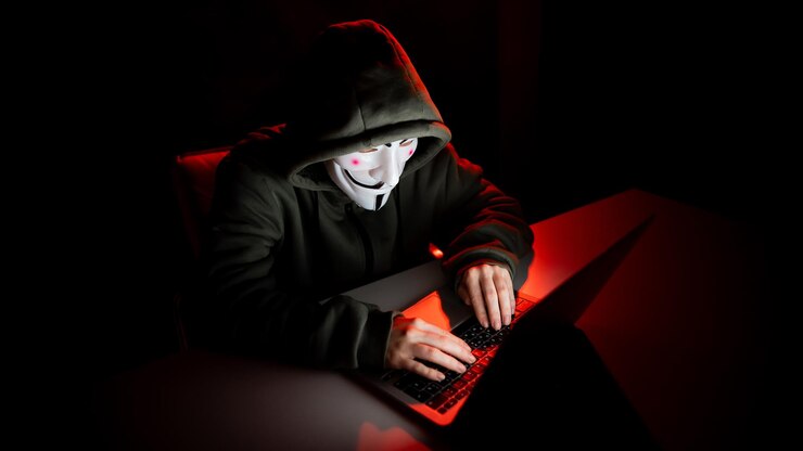 Photo june 5 2022 novosibirsk russia anonymous in a hood is typing on a laptop in the dark in red light                   person