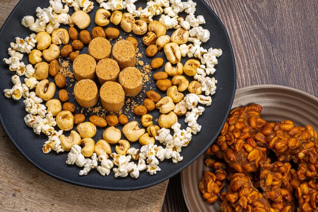 Festa di giugno arachidi popcorn caramelle arachidi e pacoca su fondo di legno rustico