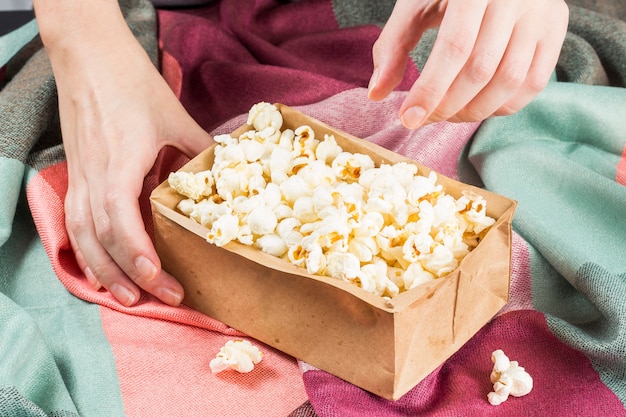 Juni viering. hand die popcorn op een gekleurde stof neemt.