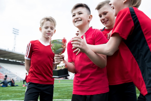 Junior football team holding cup