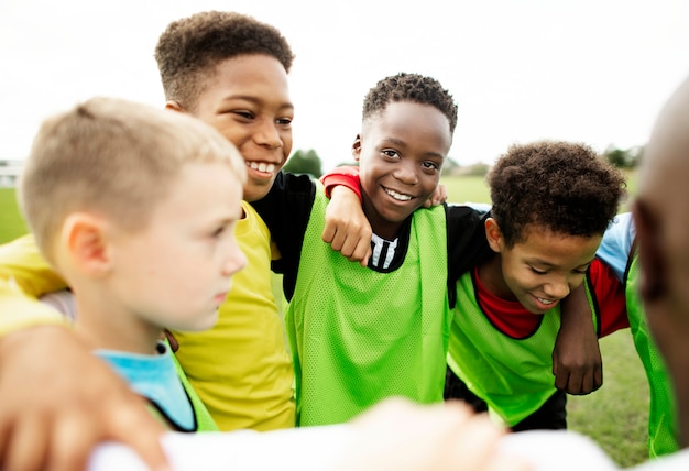 Junior football team huddling together