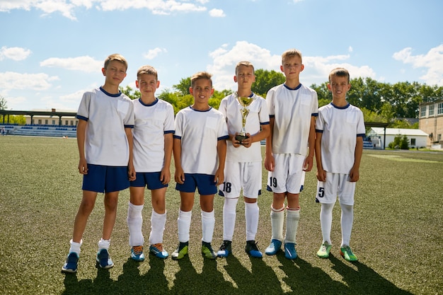 Junior Football Team Posing with Cup