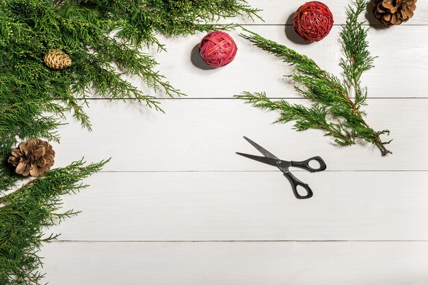 Juniper branches with a Christmas decor. Christmas, New Year background. Coniferous branches of juniper. Top view, flat design. Christmas tree on white wooden background.