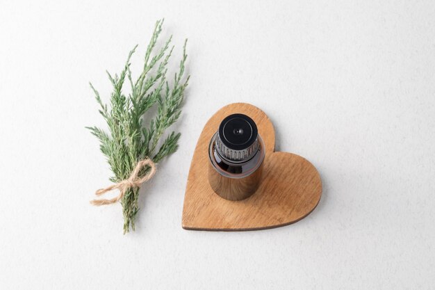 Juniper essential oil. A branch of juniper, oil in a small glass bottle.