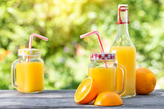 Jus d'orange en gesneden sinaasappelen op een houten tafel