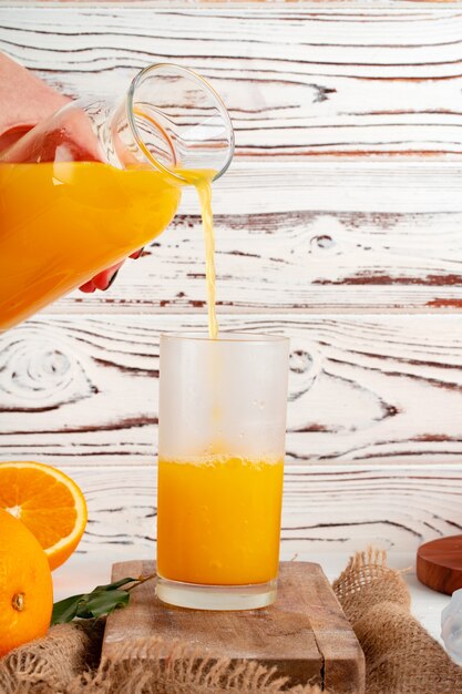 Jus d'orange gieten uit de fles in het glas