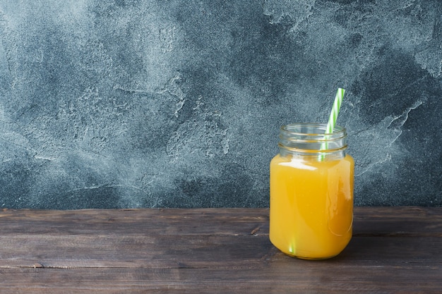 Jus d&#39;orange in glaskruik op donkere achtergrond met exemplaarruimte.