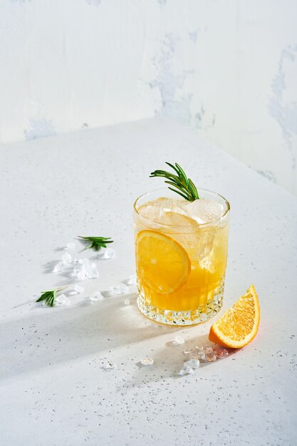 Jus d'orange of cocktail met rozemarijn en sinaasappel met ijs in glas, koude zomerlimonade