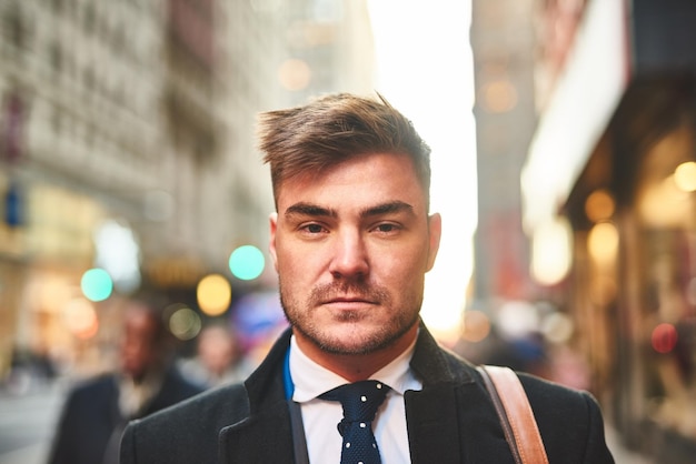 Just another man living in the city Portrait of a confident young businessman standing in the middle of the busy streets of the city during morning hours