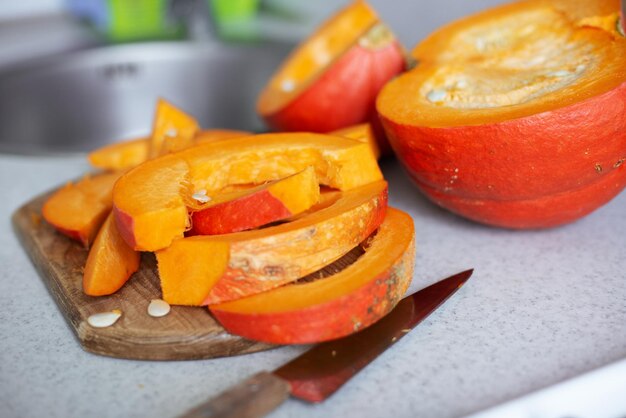 Just cut for meal preparing pumpkin slices on cutting board real photo made at authentic kitchen