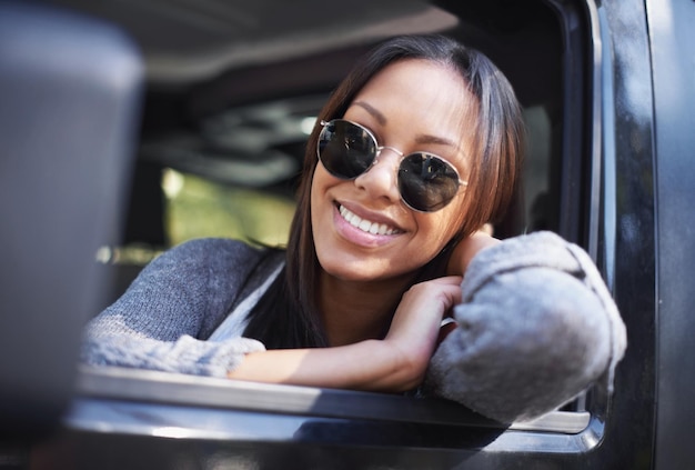 ただ乗り心地を楽しんでいる車の窓の外を見ながら笑っている若い民族の女性