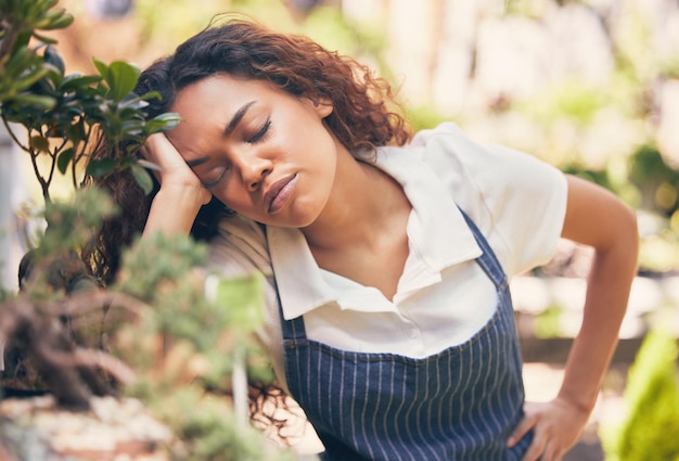 Just a few moments of rest. Shot of a young florist looking bored and tired at work.