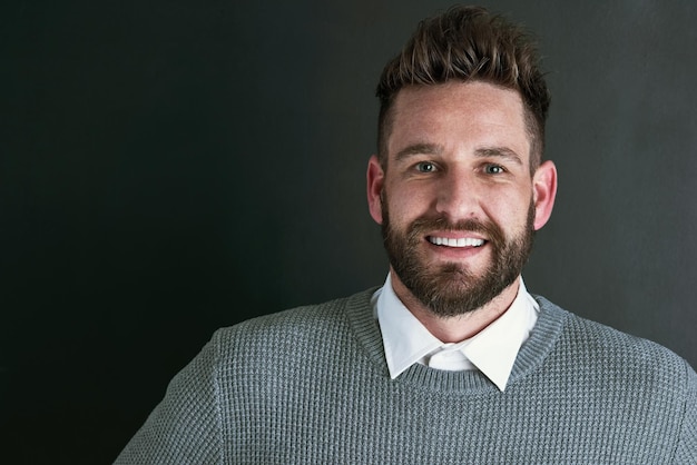 Just a friendly face in the studio Portrait of a happy young man posing against a dark background in studio