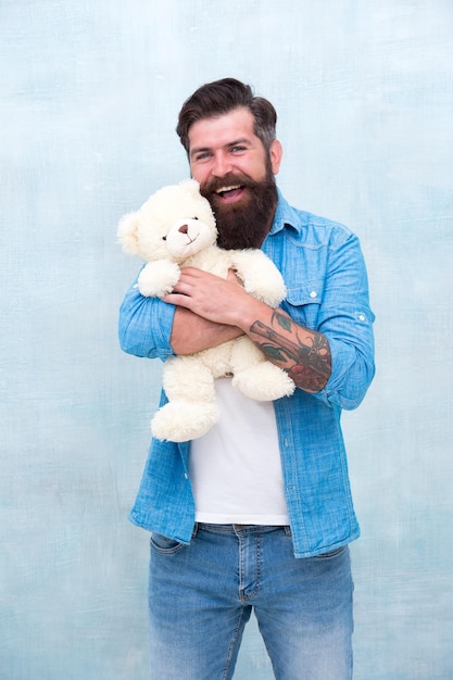 Just have fun gift for your beloved bearded male casual style man with beard on happy face happy birthday party toy shop concept brutal hipster hold lovely bear toy happy valentine day present