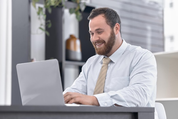 Just a little more to go before this deadline is done. Shot of a young businessman working on a laptop in an office.