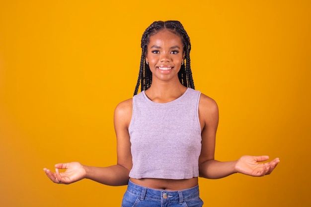 Basta guardare qui la giovane donna positiva punta le dita di entrambe le mani per copiare lo spazio isolato su giallo la studentessa attira l'attenzione sul mockup pubblicitario