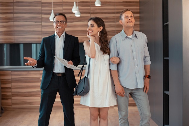 Just married couple buying house standing near real estate agent