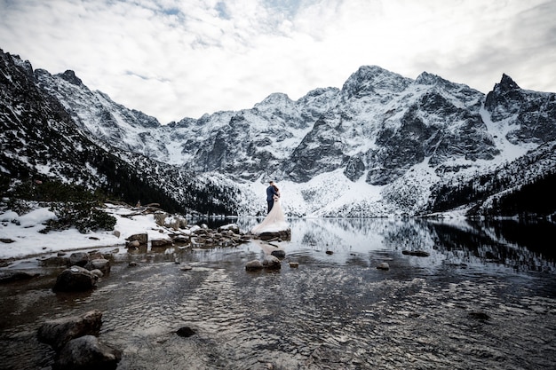 Just married couple kissing on mountains landscape