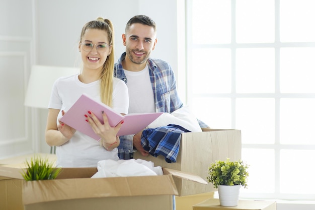 A just married couple unpacking boxes and moving into a new home Positive emotion