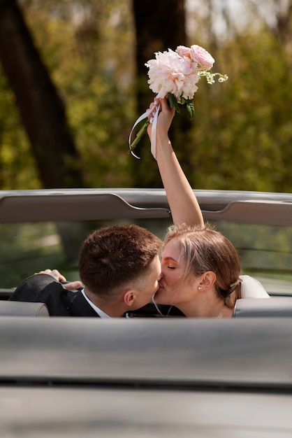 車で結婚したばかりのカップル