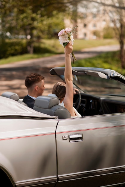車で結婚したばかりのカップル