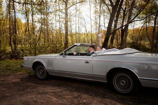 車で結婚したばかりのカップル