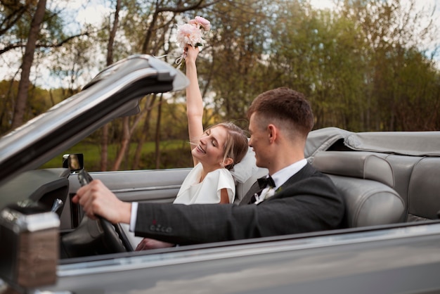 車で結婚したばかりのカップル