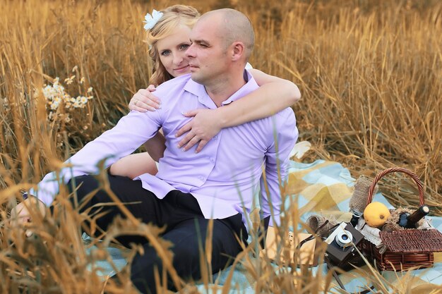 Just married lovers walking in a field in autumn day