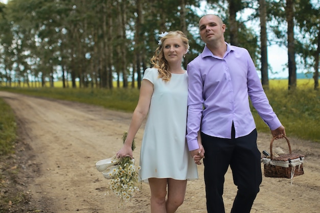 Just married lovers walking in a field in autumn day