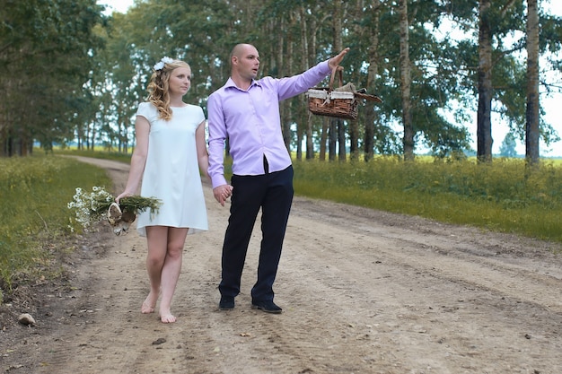 Just married lovers walking in a field in autumn day