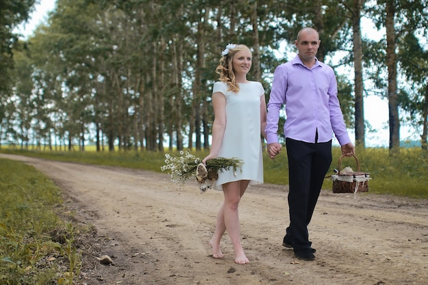 Just married lovers walking in a field in autumn day