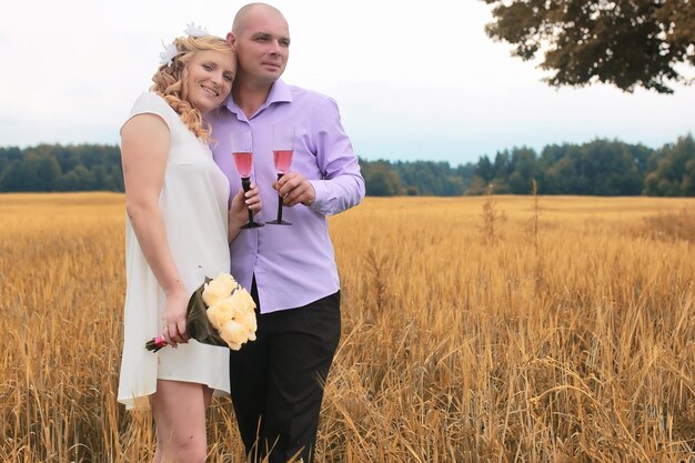 Just married lovers walking in a field in autumn day