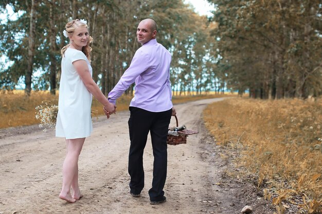 Photo just married lovers walking in a field in autumn day