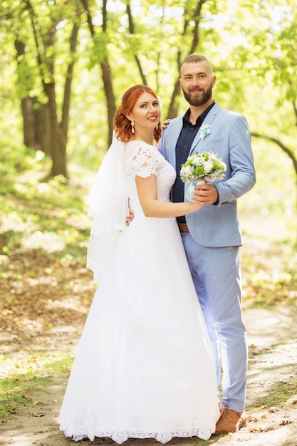 Just married loving hipster couple in wedding dress and suit in the park