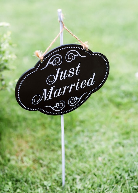 "Just married" sign on green grass in the backyard