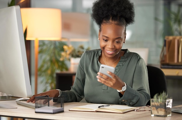 Just the message Ive been waiting for. Cropped shot of an attractive young businessman sending a text while working at her desk in the office.