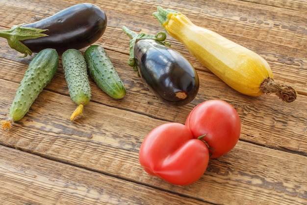 Just picked tomatoes cucumber eggplants and squash on old wooden boards Top view